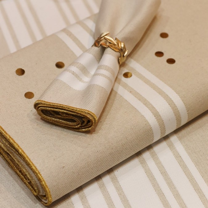 beige napkin with white stripes and gold embroidery