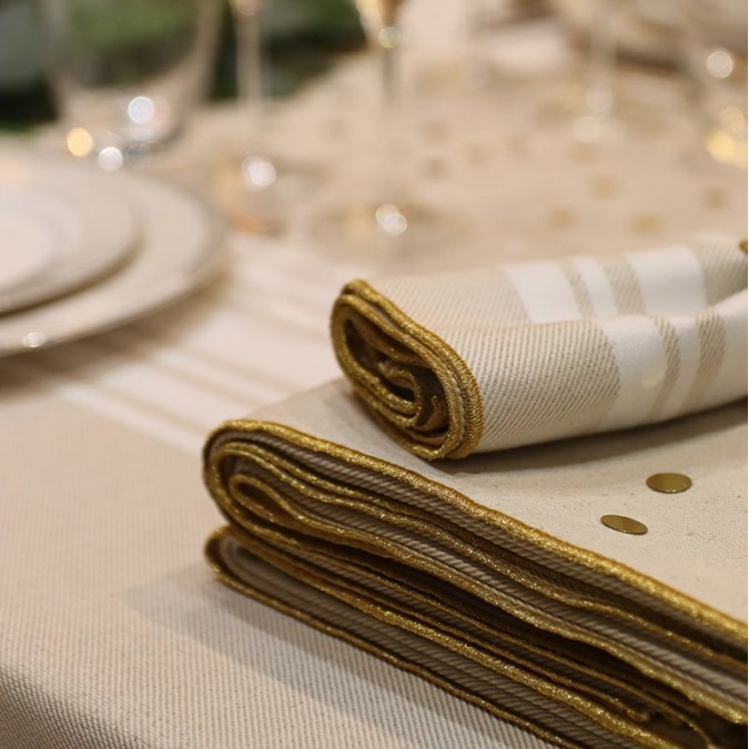 beige and white linen and cotton napkin with stripes and gold embroidery