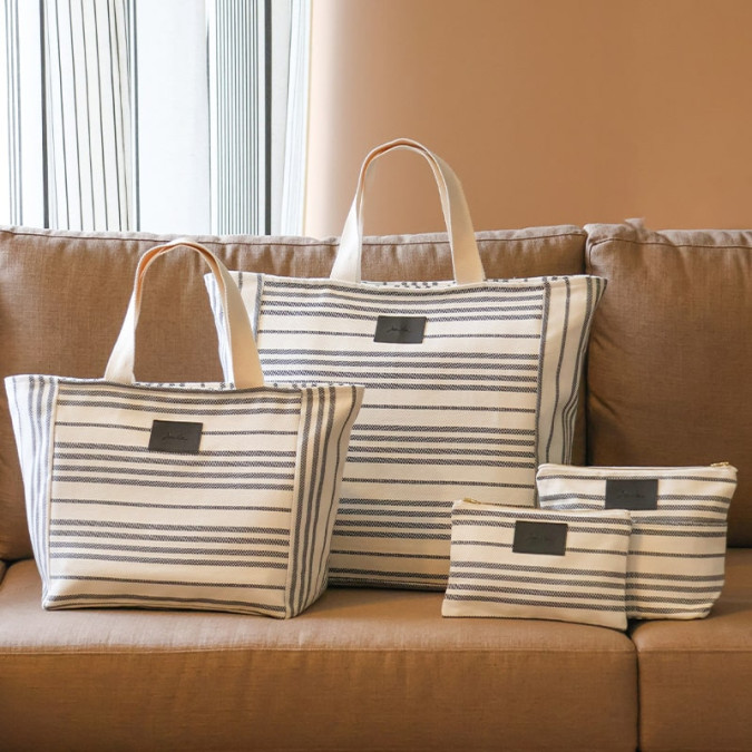 Bolso de mano beige y negro con elegantes rayas
