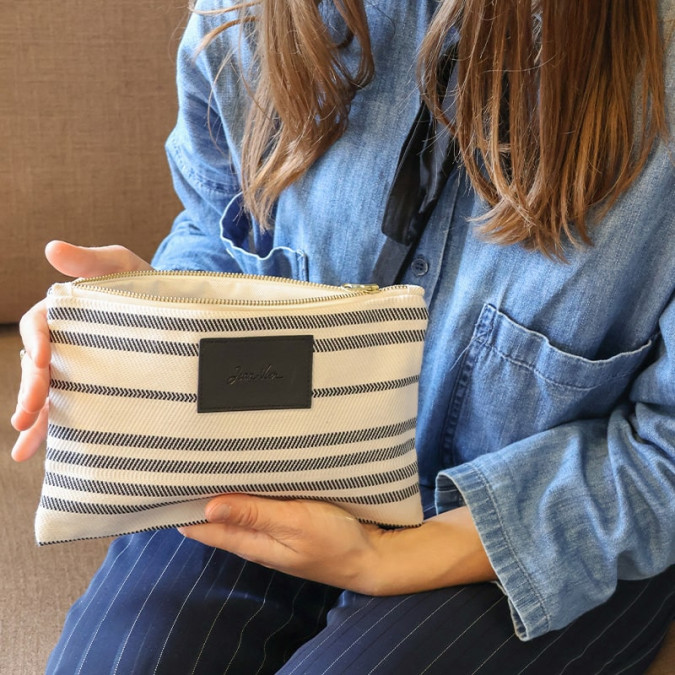 Elegante bolso de mano plano beige de alta gama con rayas negras