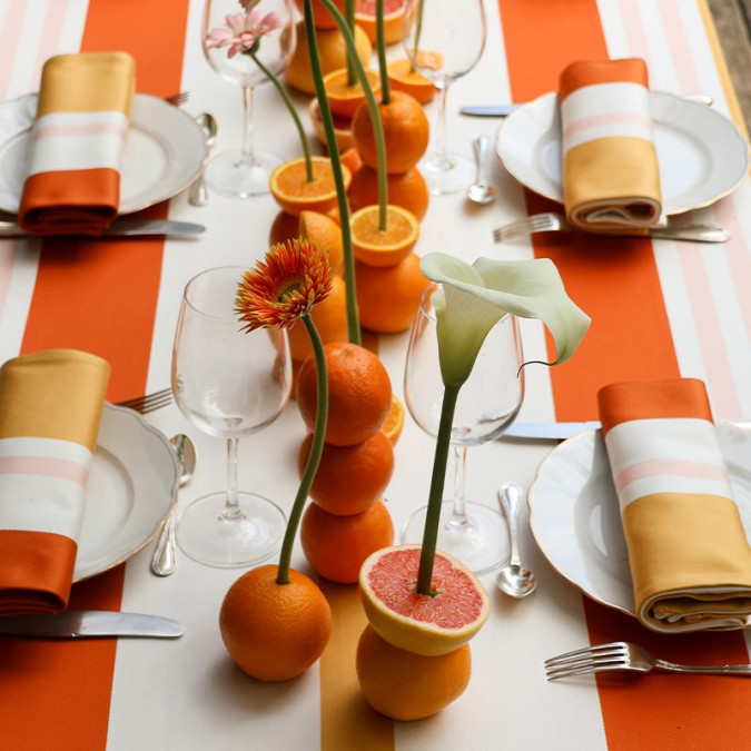 Elegante mantel antimanchas a rayas naranjas, amarillas y rosas