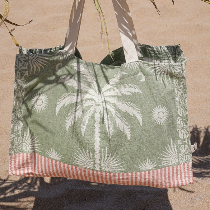 Green beach bag with white palm tree motif and trendy red stripes